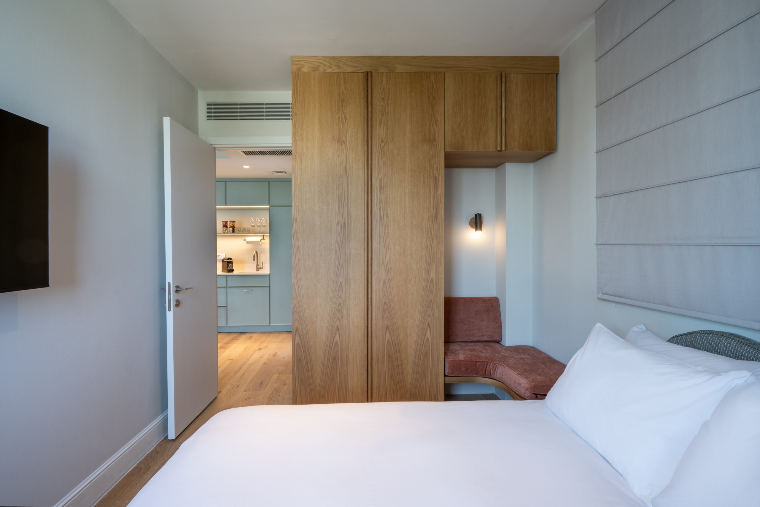 Comfortable and elegantly designed bedroom in the One-Bedroom with Big Terrace & Sofa Bed at master Mazeh Tel Aviv, featuring a plush bed and warm lighting.