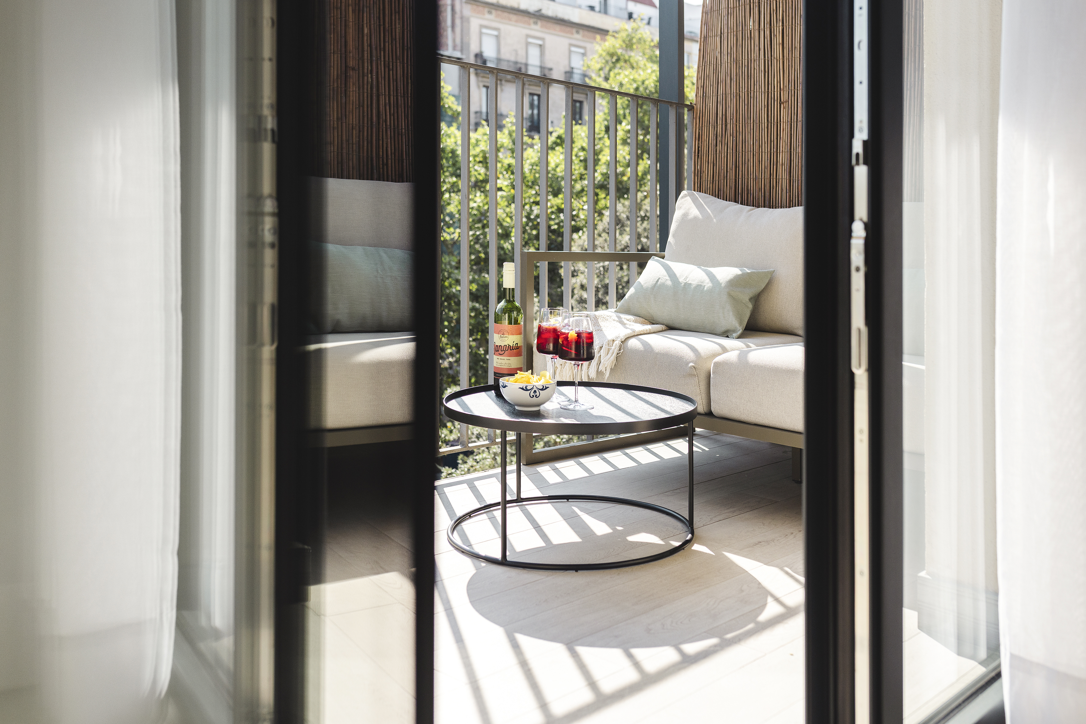 Private balcony at master La Rambla Barcelona with lounge seating, sangria glasses, and city views.