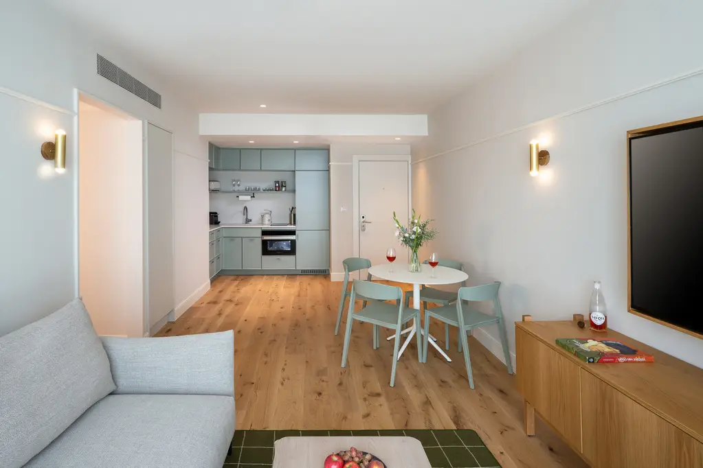 Modern kitchen in the Two-Bedroom with Sofa Bed at master Mazeh Tel Aviv, featuring a sleek dining table for a stylish and functional space.