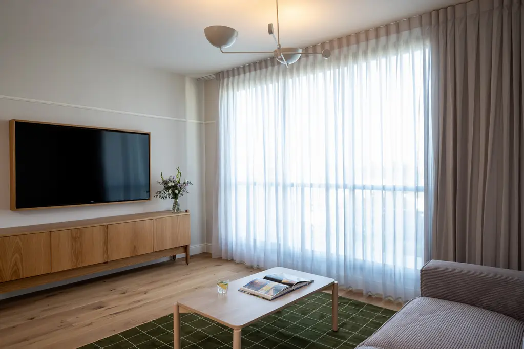Bright and inviting living space in the One-Bedroom at master Mazeh Tel Aviv, designed for comfort with contemporary furnishings.