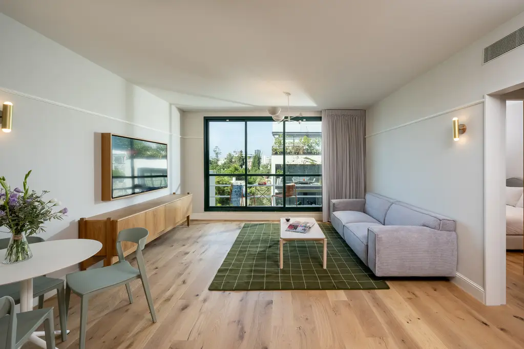 Well-designed living space at master Mazeh Tel Aviv, blending comfort and contemporary aesthetics with a plush sofa.